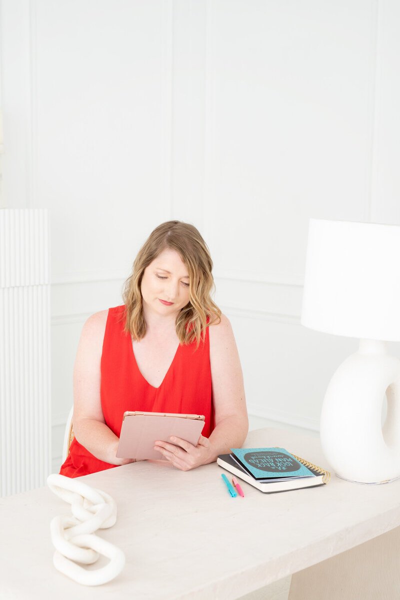 Tara Reid reviewing notes on a tablet at her desk